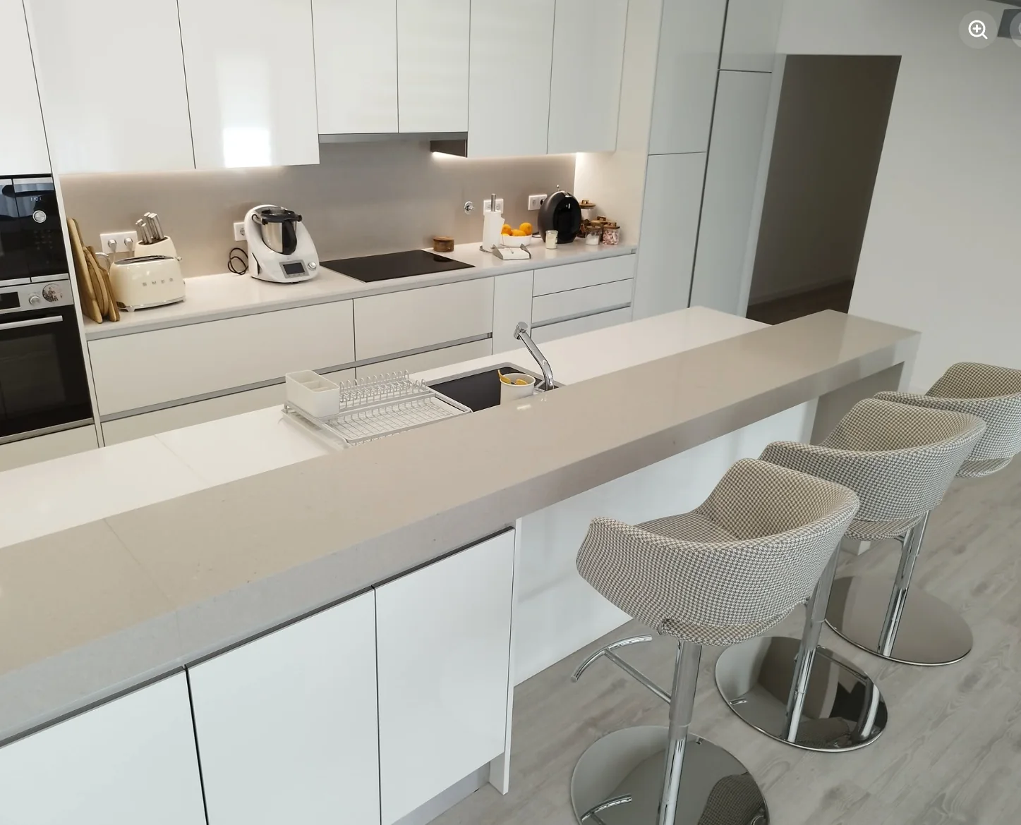Cozinha branca com ilha e bancos